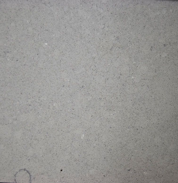 A close up of a gray tile with a circle in the middle.