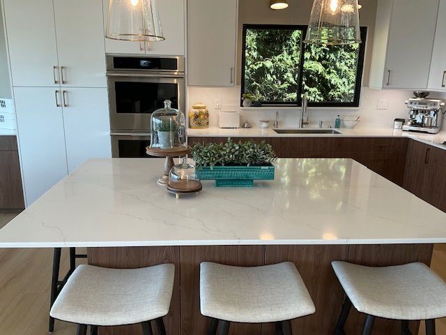 A kitchen with a large island and three stools