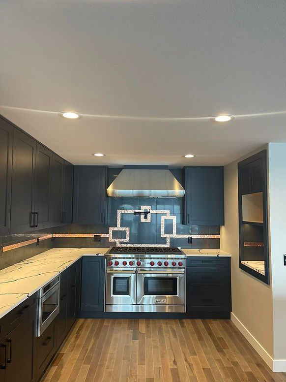 A kitchen with black cabinets and stainless steel appliances.