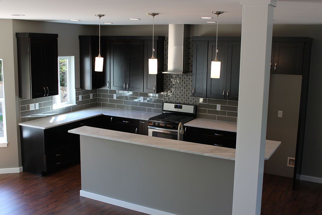 A kitchen with black cabinets and a stove top oven