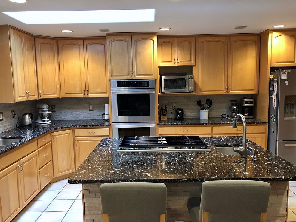 A kitchen with wooden cabinets and granite counter tops