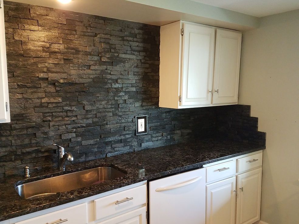 A kitchen with white cabinets and a stainless steel sink
