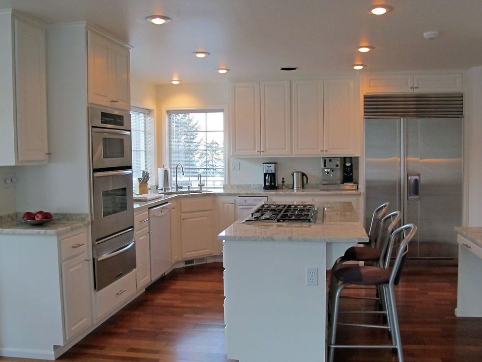 A kitchen with white cabinets and stainless steel appliances