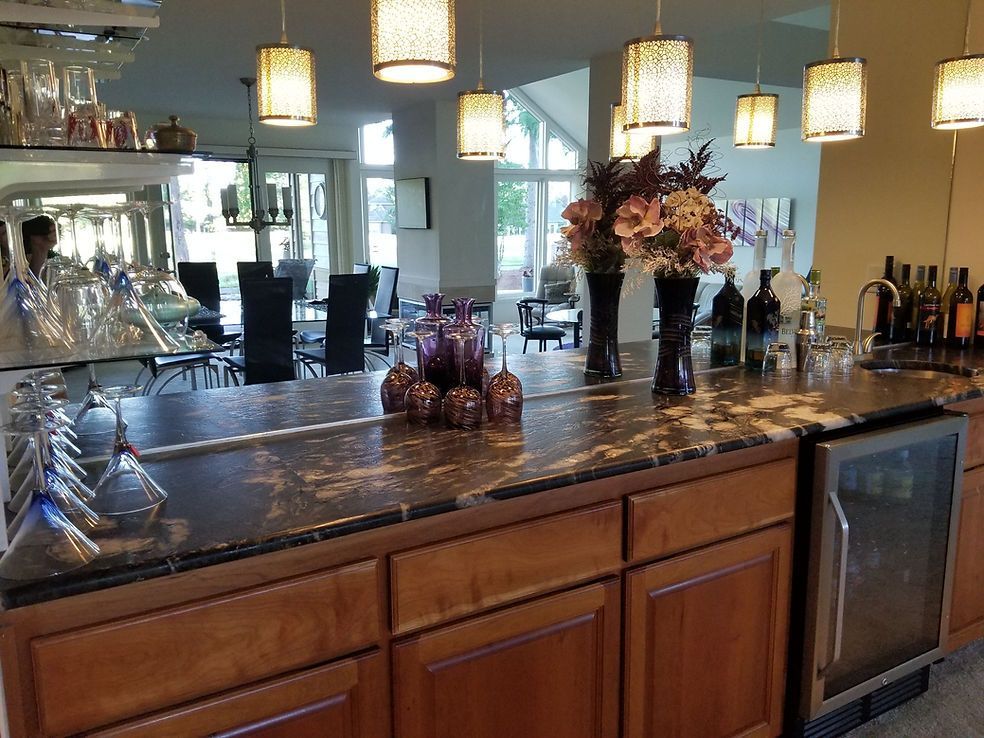 A kitchen with a bar and a refrigerator.