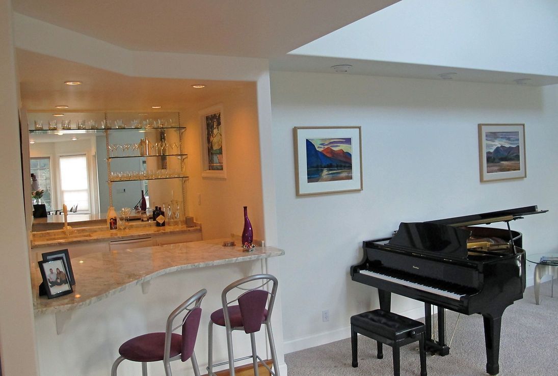 A living room with a piano and a bar