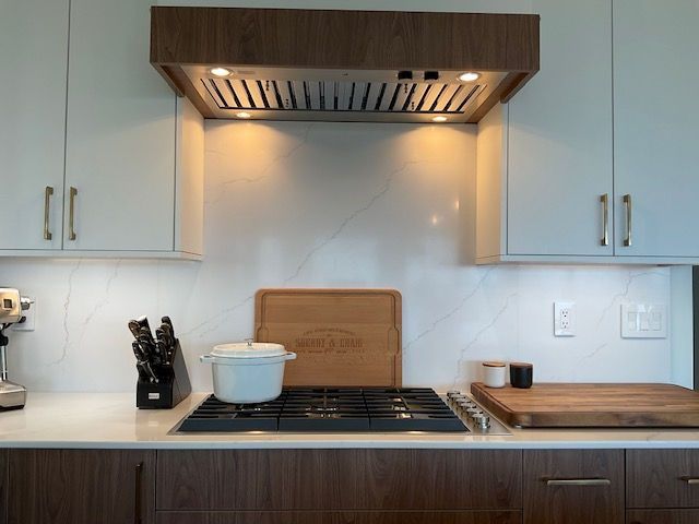 A kitchen with a stove top oven and a cutting board