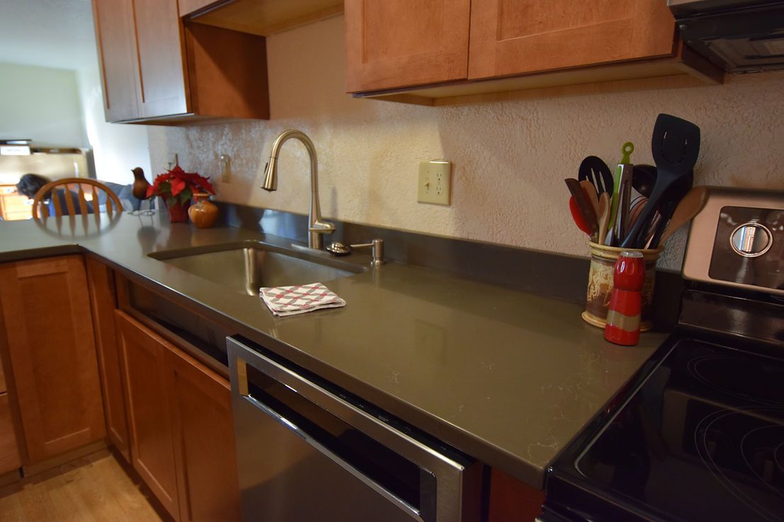 A kitchen with a sink , stove and dishwasher