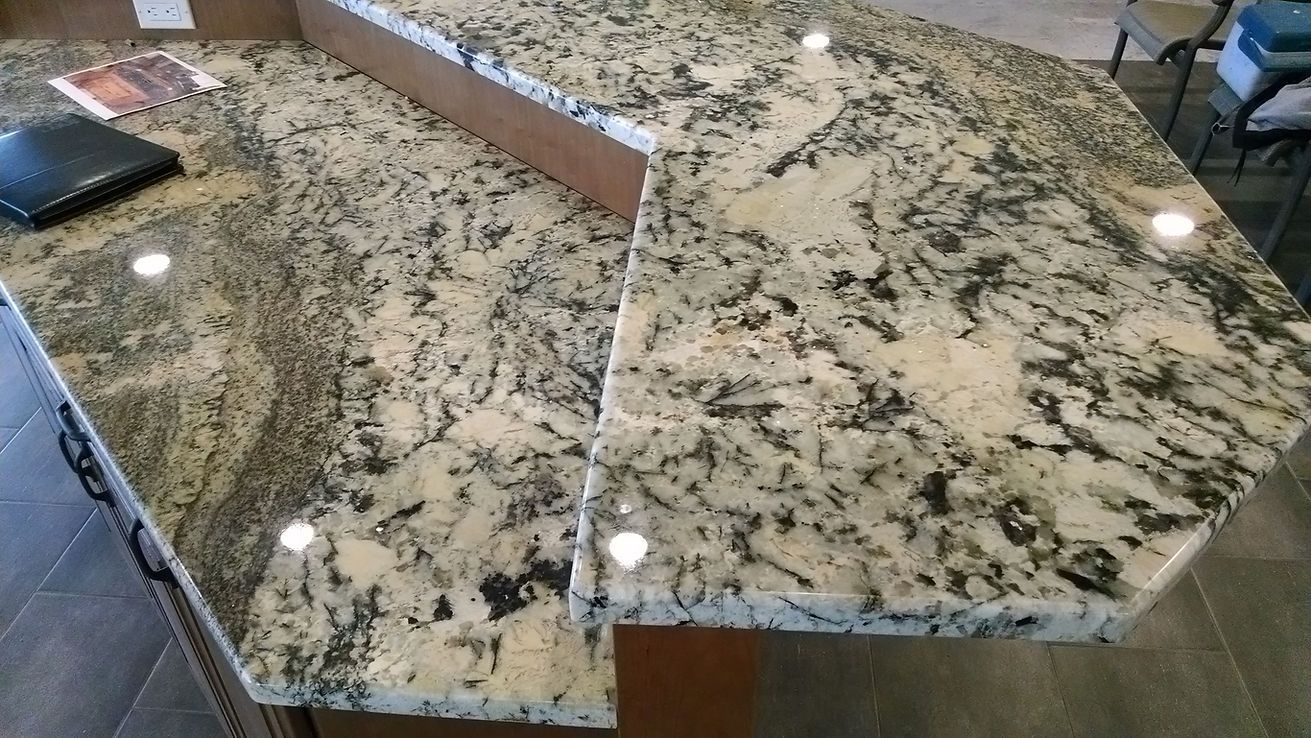A close up of a granite counter top in a kitchen.