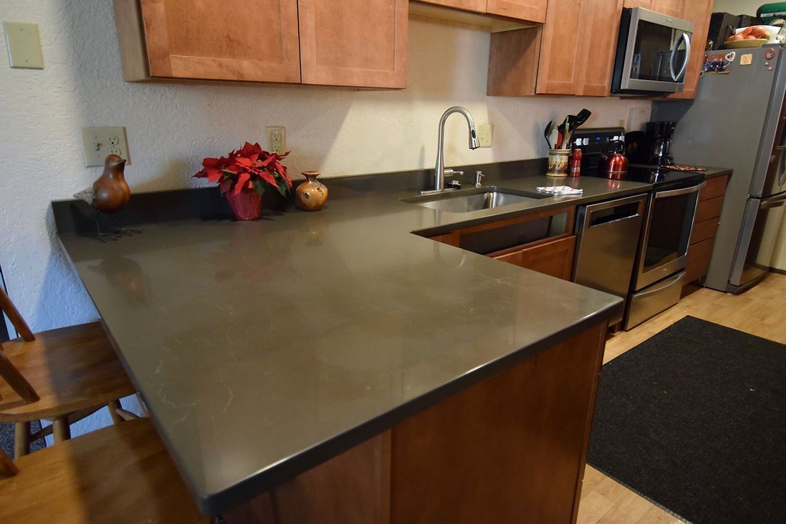 A kitchen with a sink , stove and microwave.