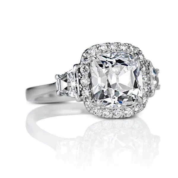 a diamond ring with a cushion cut diamond in the center