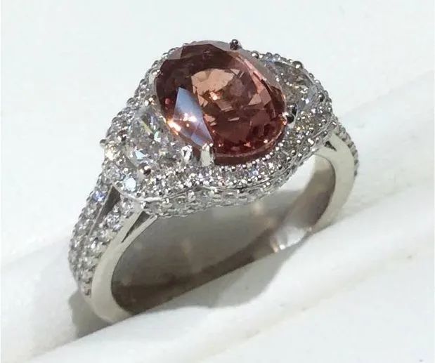 a white gold ring with a pink stone and diamonds