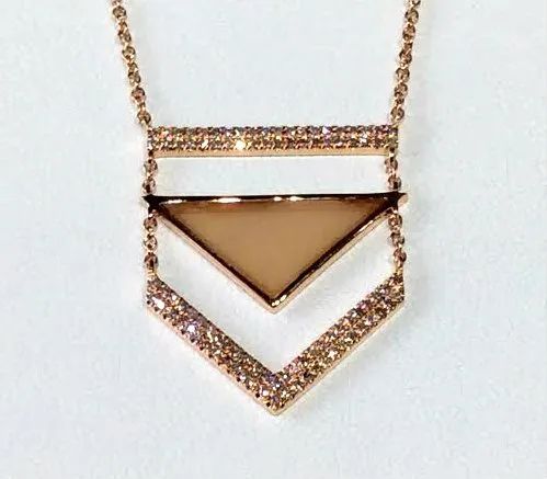 a gold necklace with a triangle shaped pendant on a chain