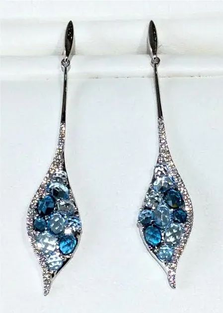 a pair of earrings with blue stones and diamonds