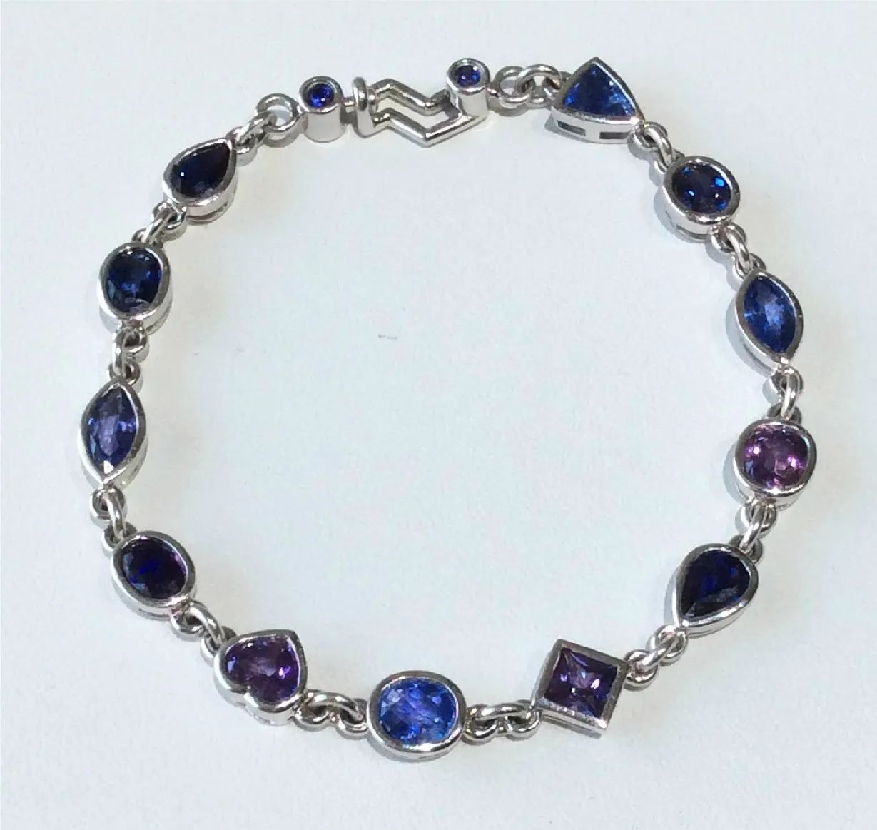 a silver bracelet with purple and blue stones