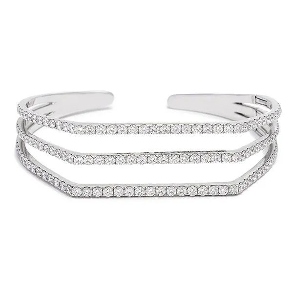 a silver cuff bracelet with three rows of diamonds on a white background