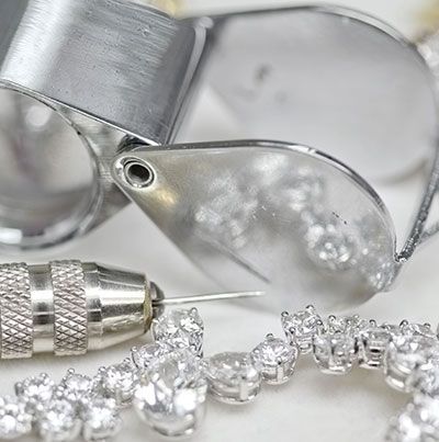a close-up of a necklace and a magnifying glass on a table.