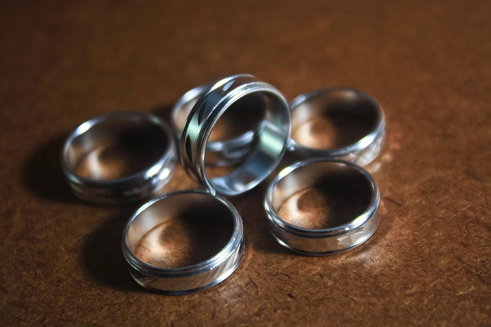 a group of silver rings are sitting on a brown surface.