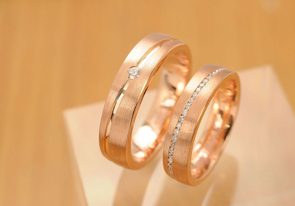 a pair of wedding rings are sitting on top of each other on a table.