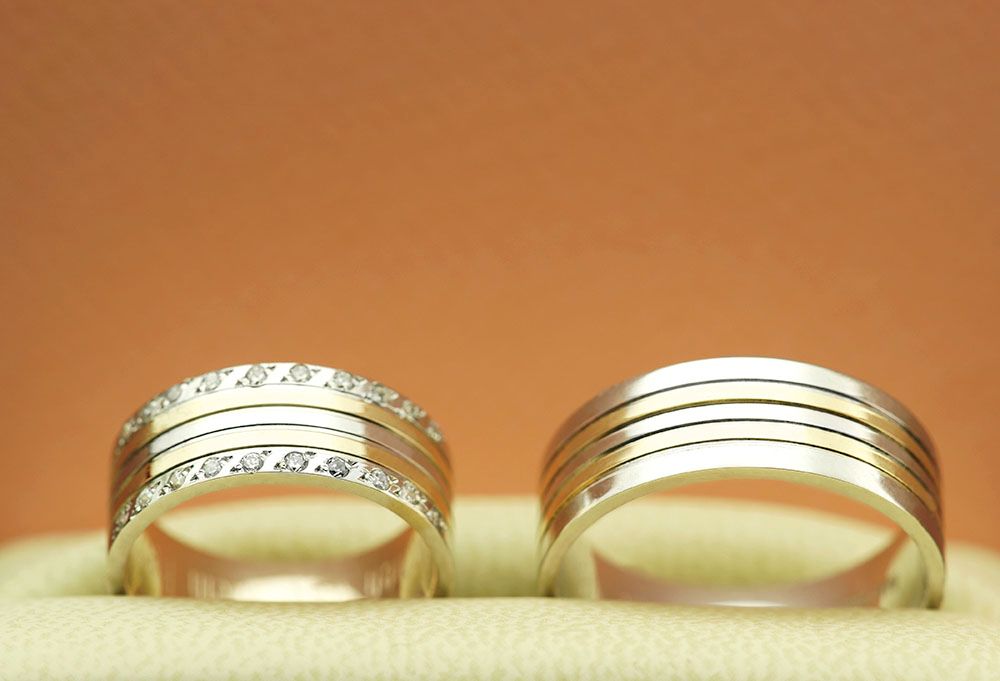 a pair of wedding rings sitting on top of each other.