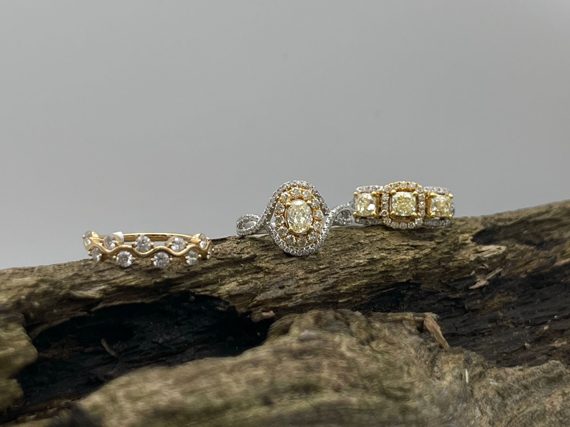 Three rings are sitting on top of a piece of wood.