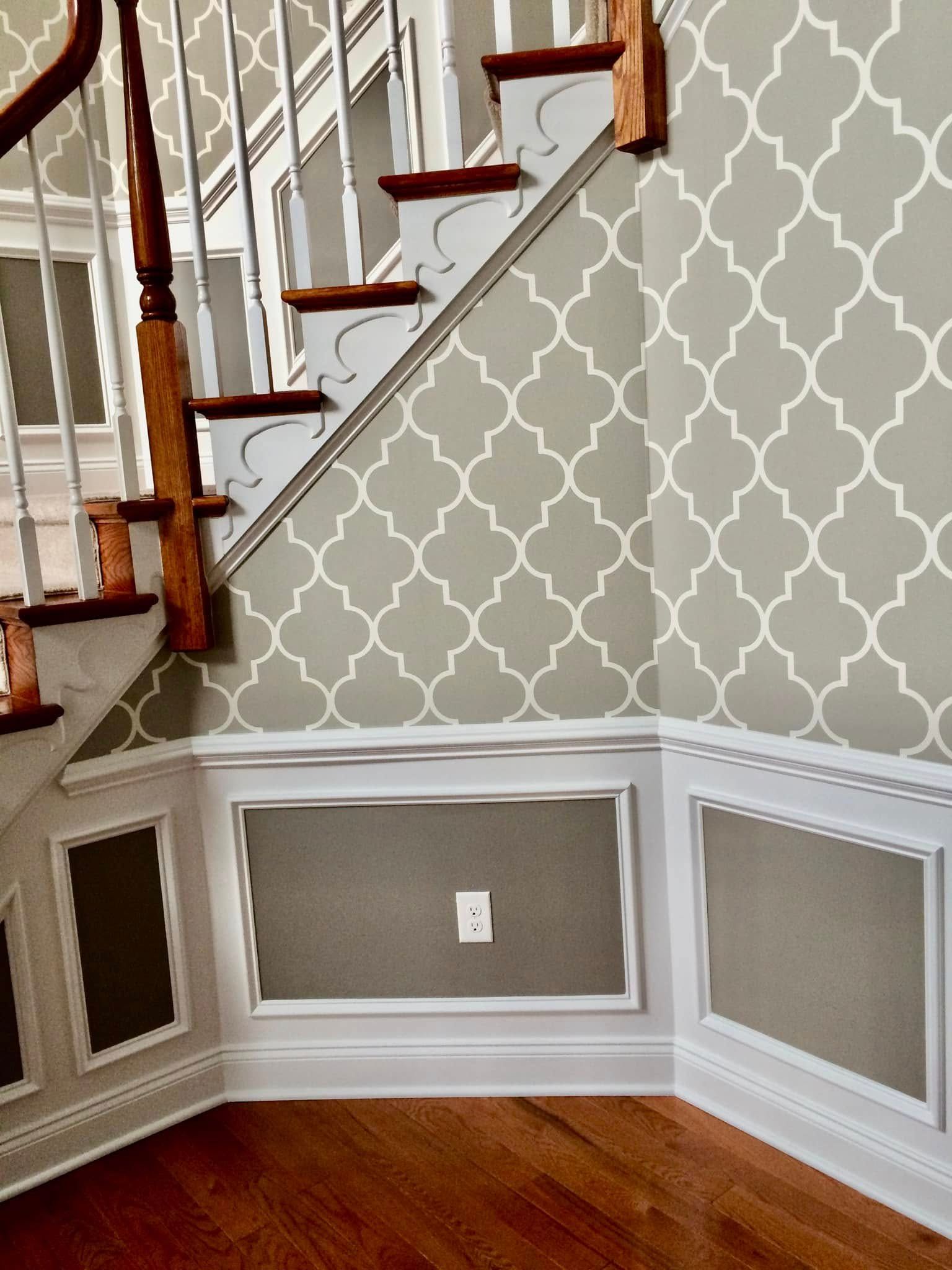A staircase with a patterned wallpaper on the wall