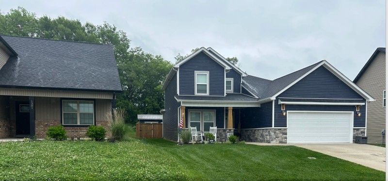 A house with a blue siding and a white garage door