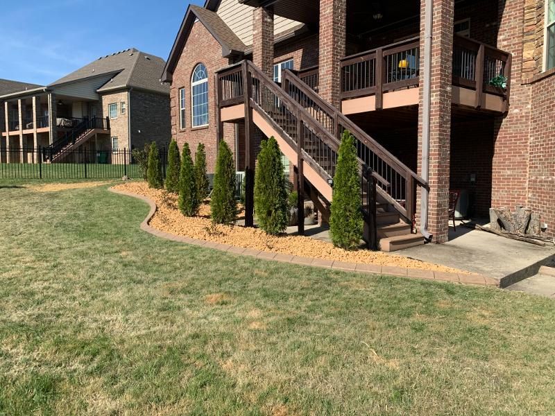 A large brick house with stairs leading up to the second floor.