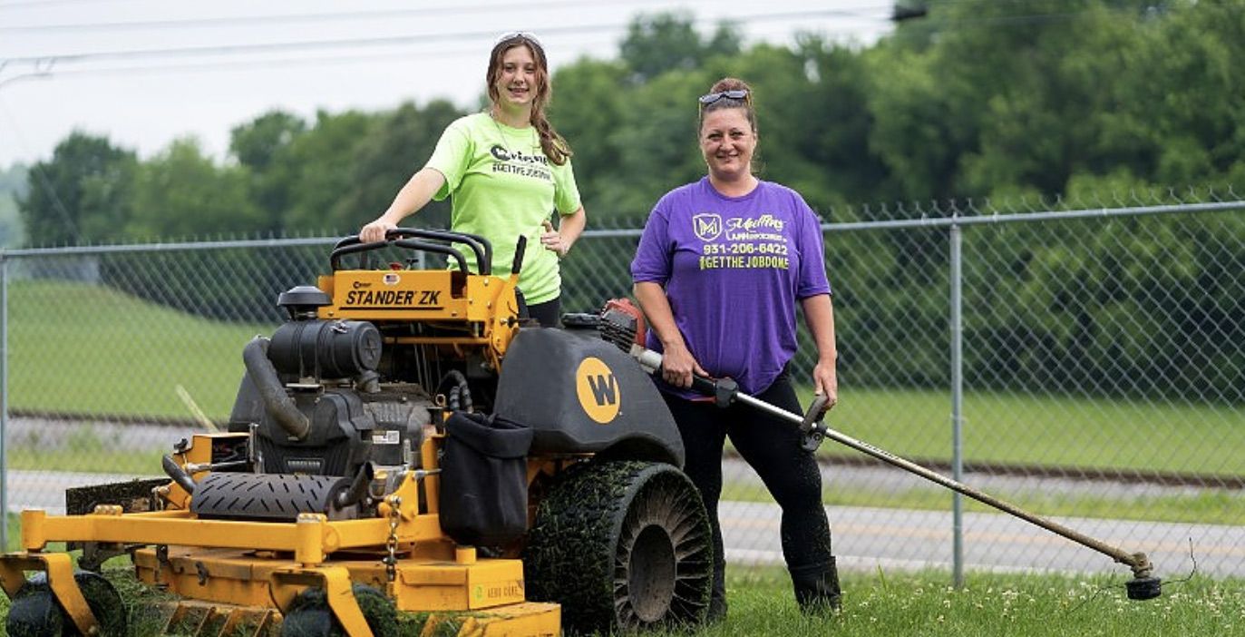 A man is spraying a lawn with a sprayer.