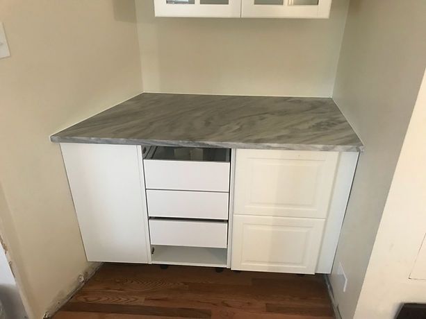 A kitchen with white cabinets and a granite counter top.