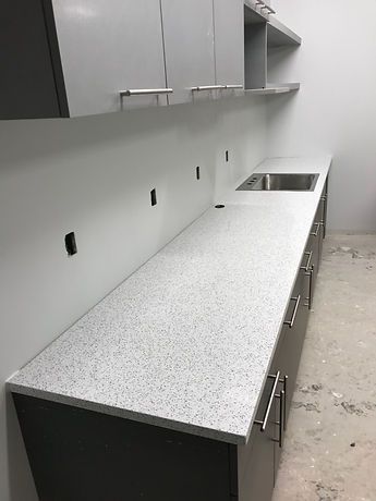 A kitchen with a long counter top and a sink.