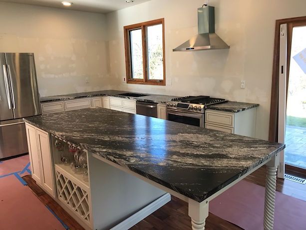 A kitchen with granite counter tops and stainless steel appliances.