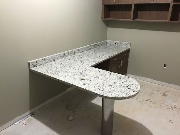 A white granite desk is sitting in a corner of a room.