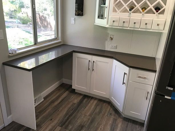 A kitchen with white cabinets and a wine rack on the wall.