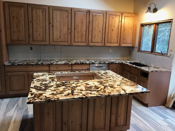 A kitchen with wooden cabinets and granite counter tops.