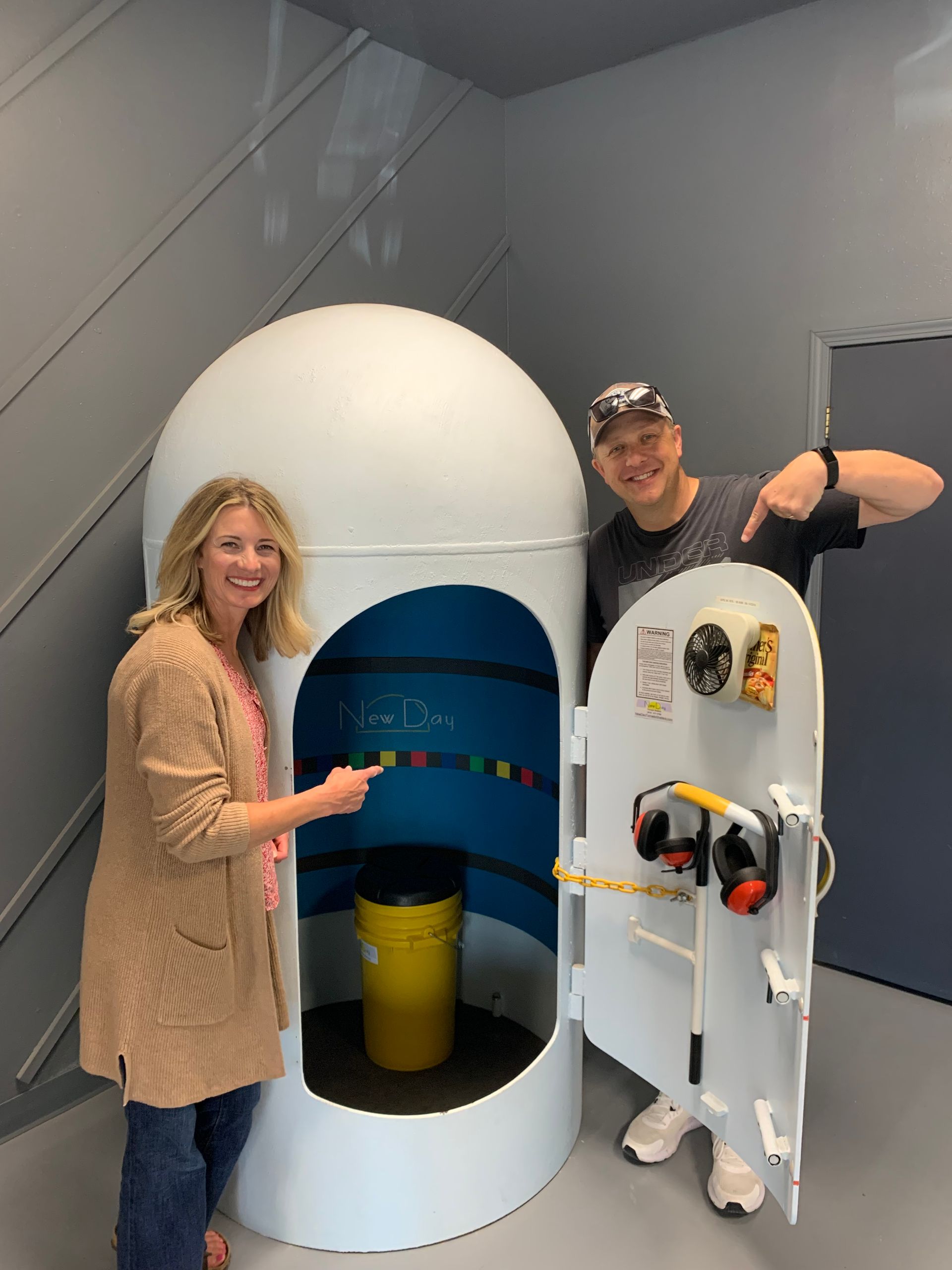 A man and a woman are standing in front of a large white dome.