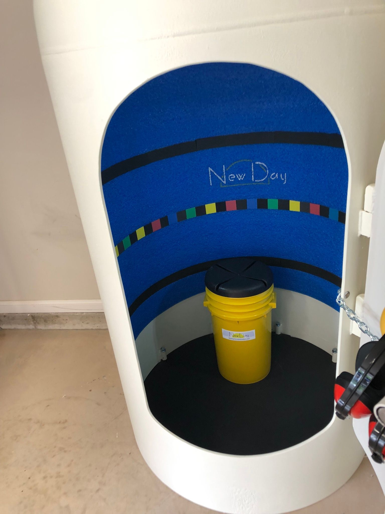 A yellow bucket sits inside a white container that says new day