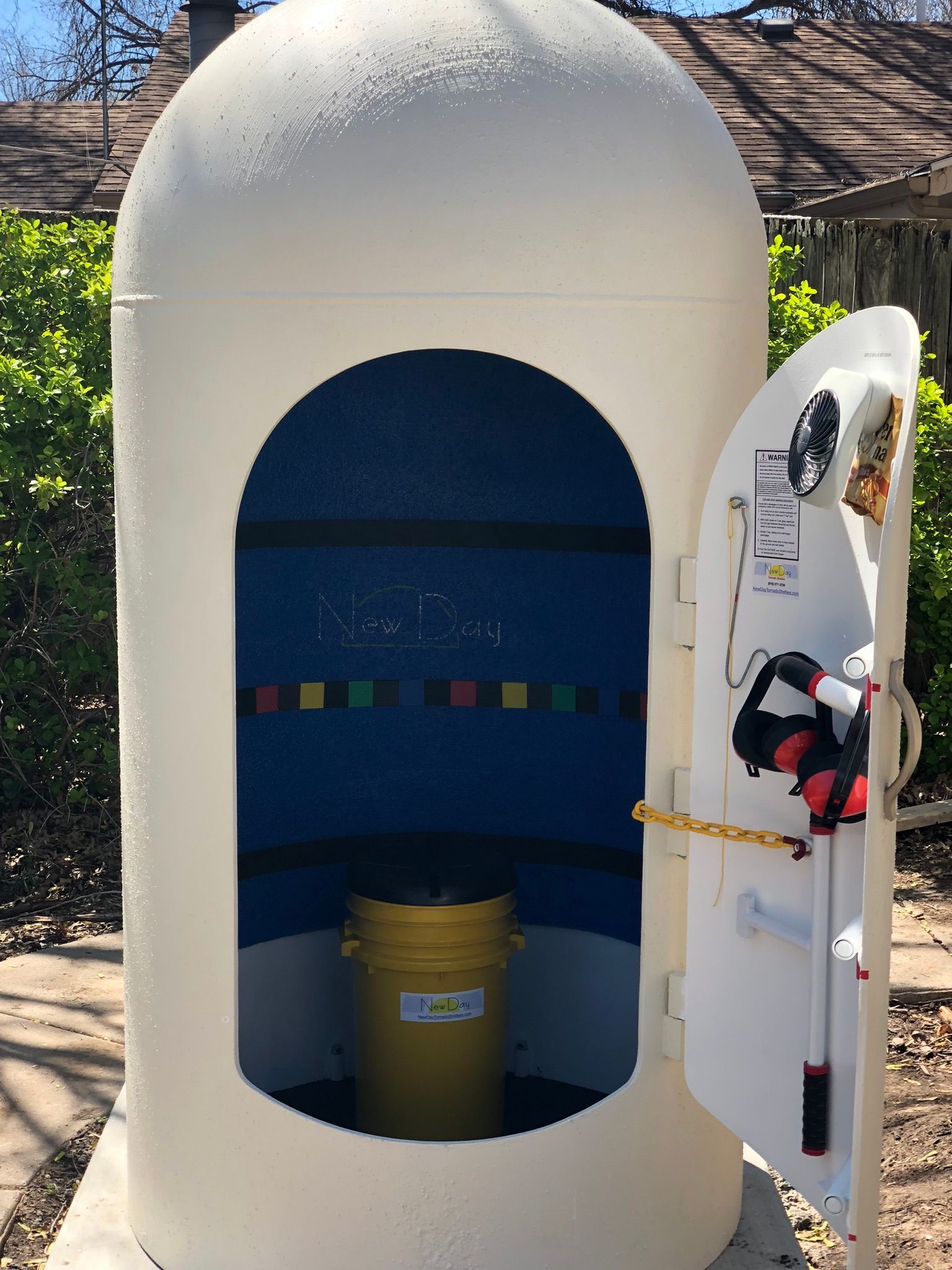 A white container with the door open and a yellow bucket inside