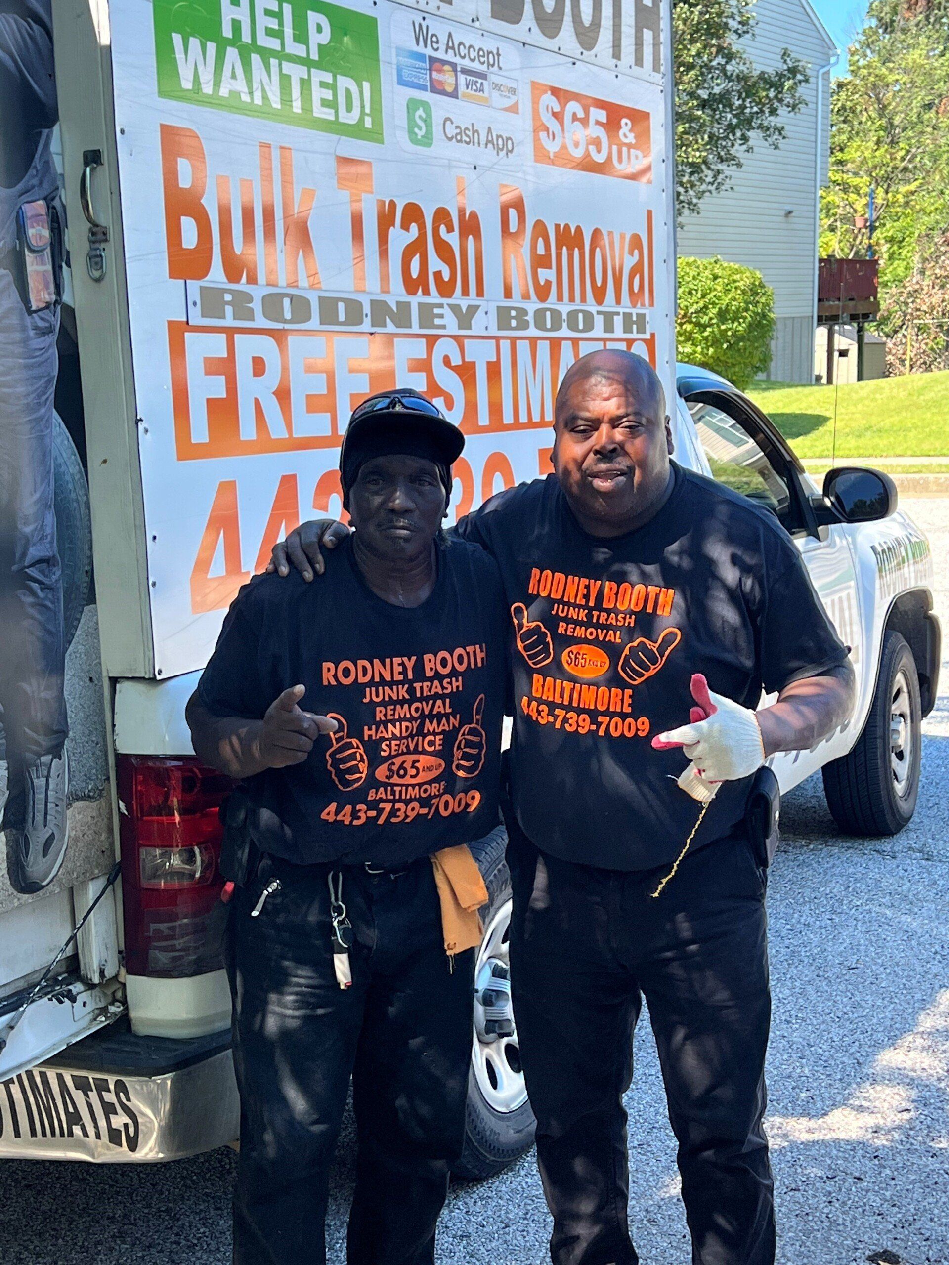 two men in front of bulk trash removal truck