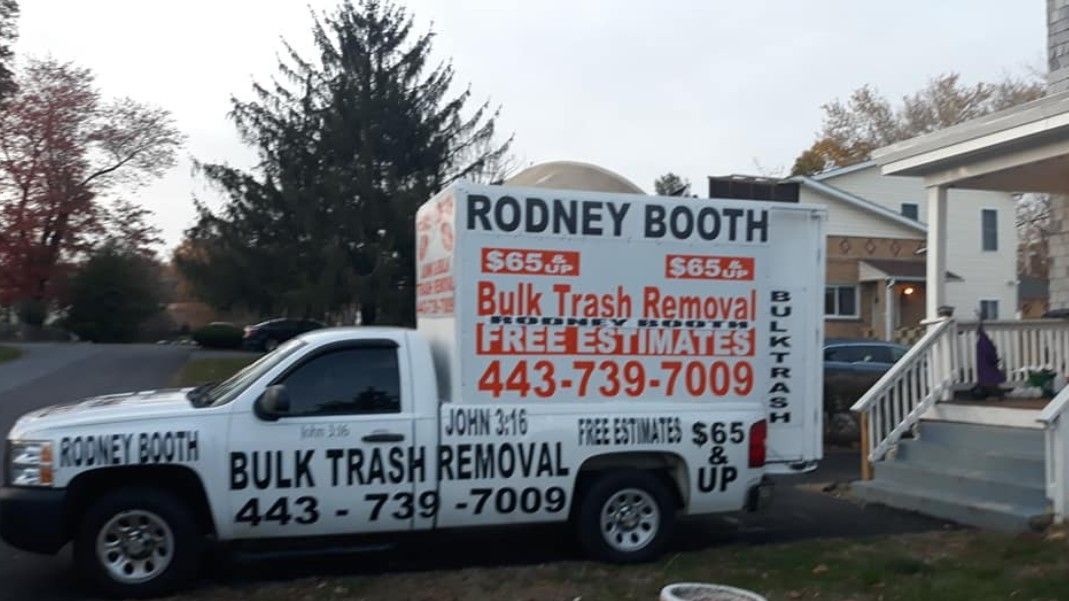 White truck with Rodney Booth Bulk Trash Removal on side. Phone number and price displayed.