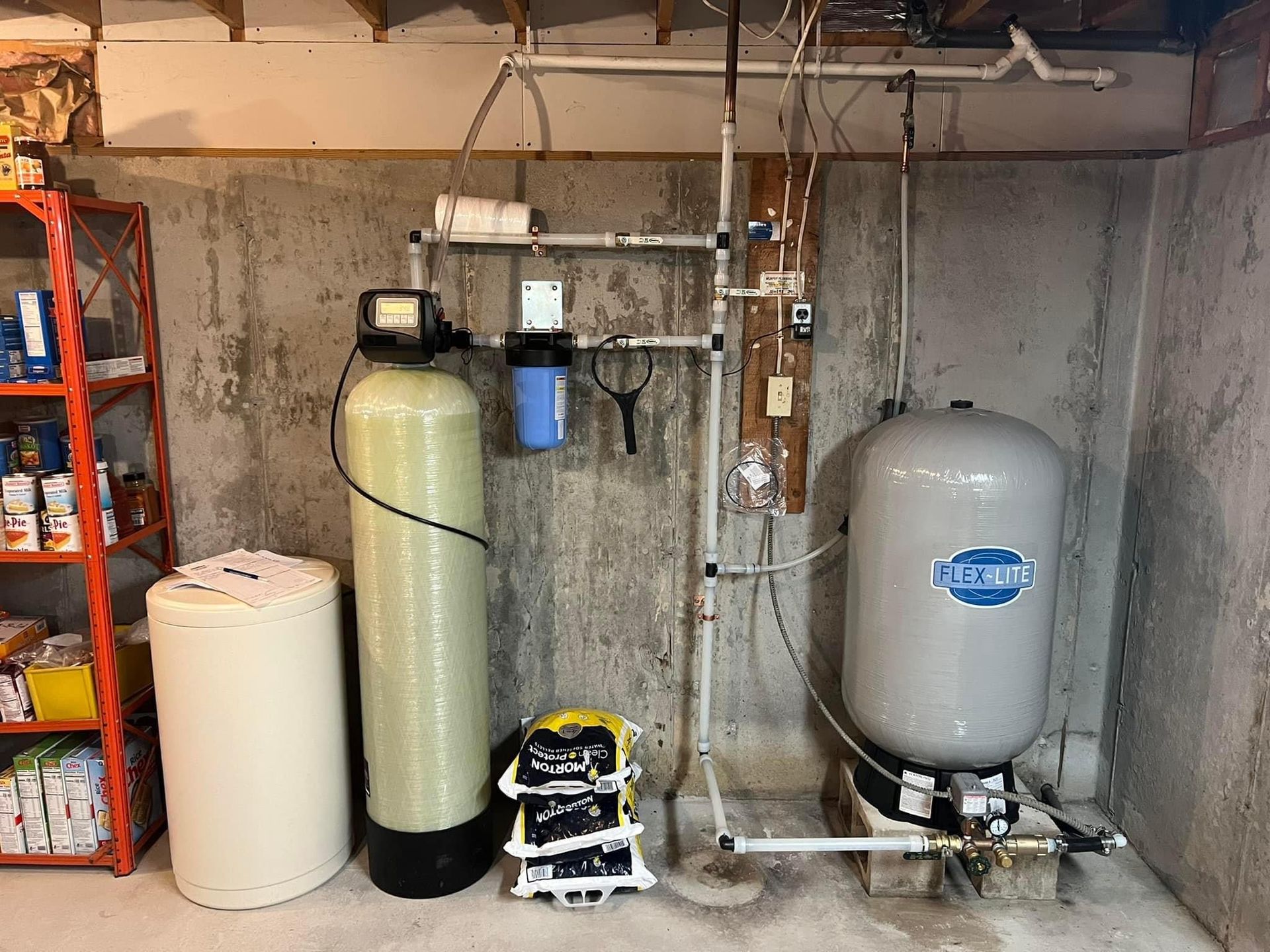 Water filtration system in a basement, including a water softener, sediment filter, and pressure tank.