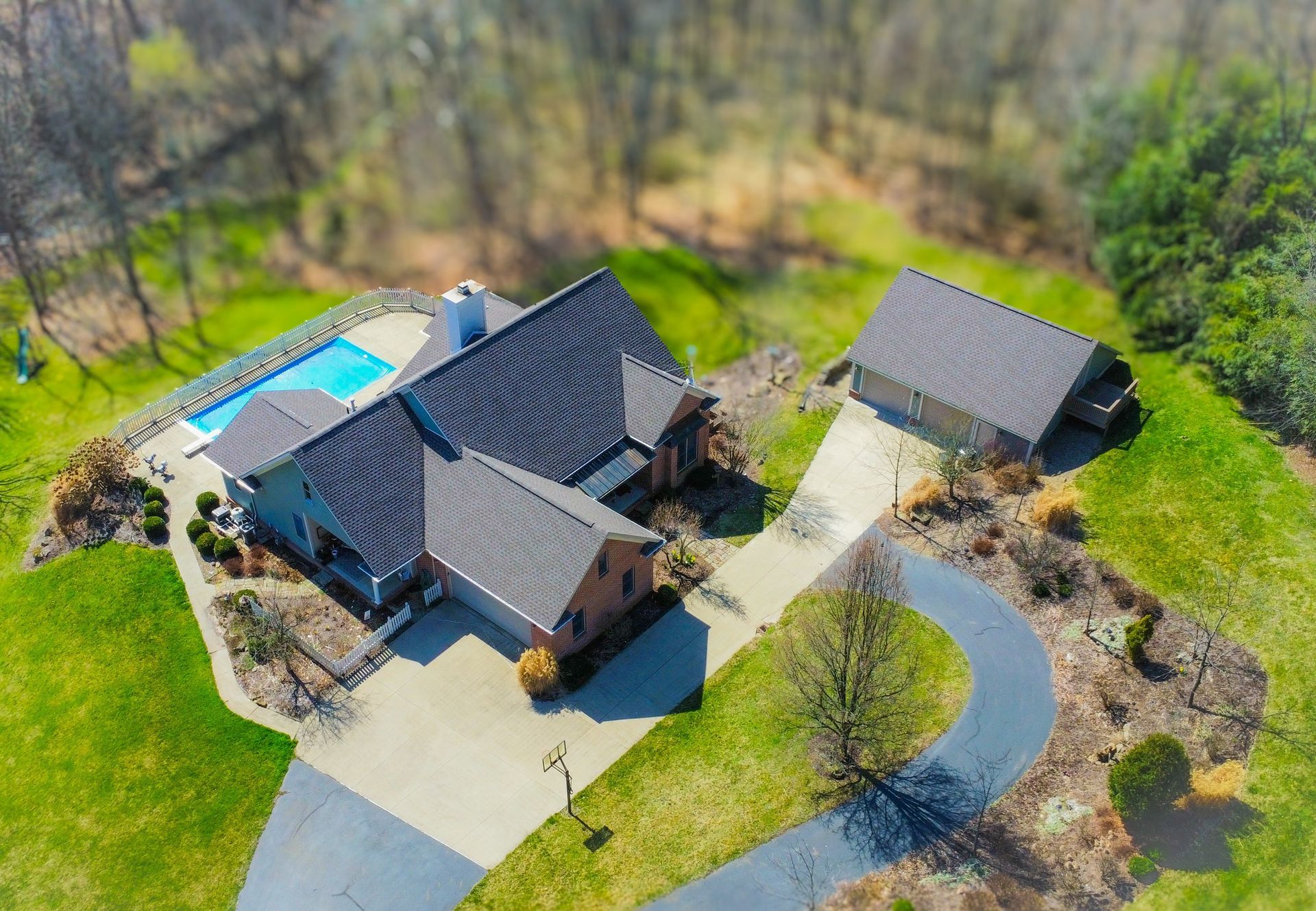 An aerial view of a house with a pool in the backyard