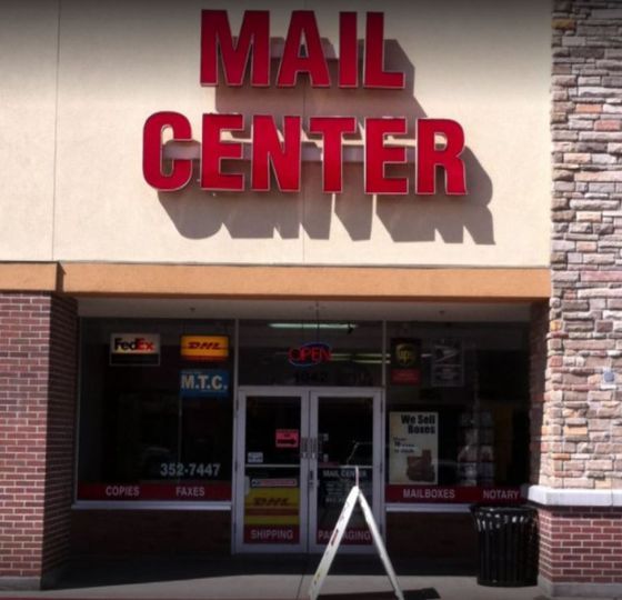 Mail Center storefront with red sign, glass doors, and shipping services advertised.