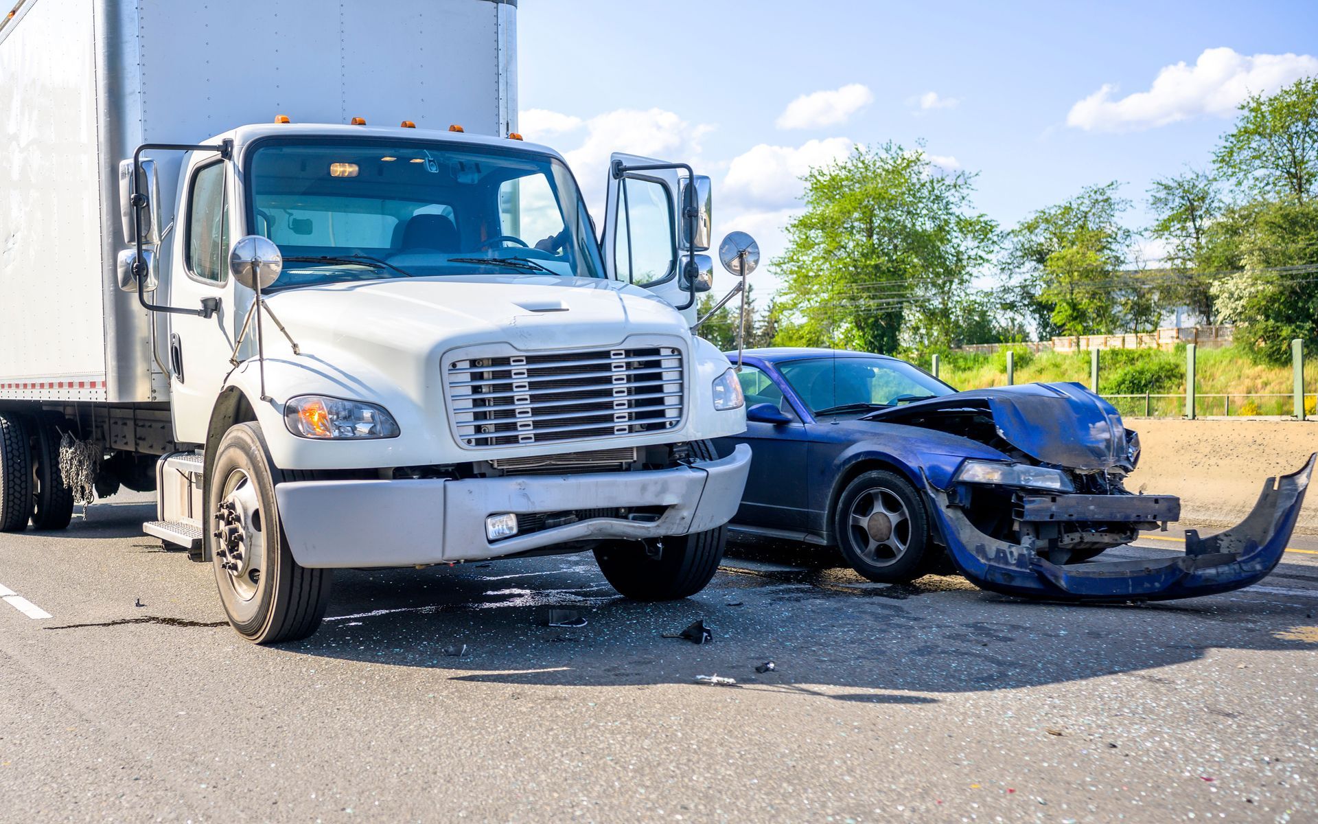 A truck and a car are involved in a traffic accident on the highway.