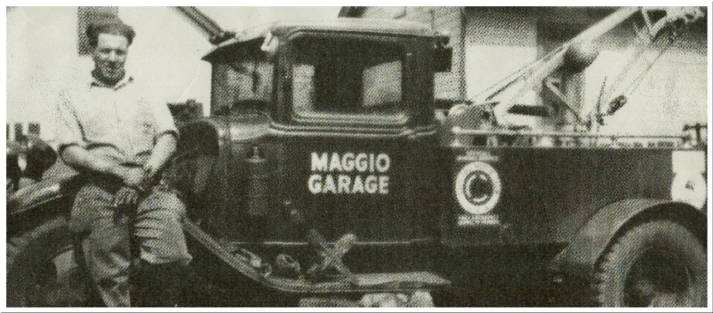 Man leans on vintage tow truck, 