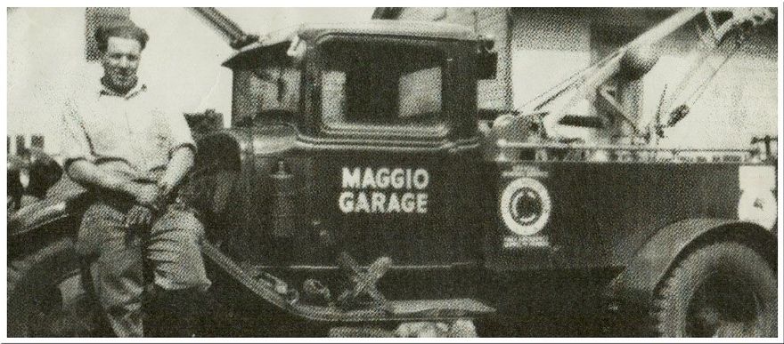 Man leans on vintage tow truck, 