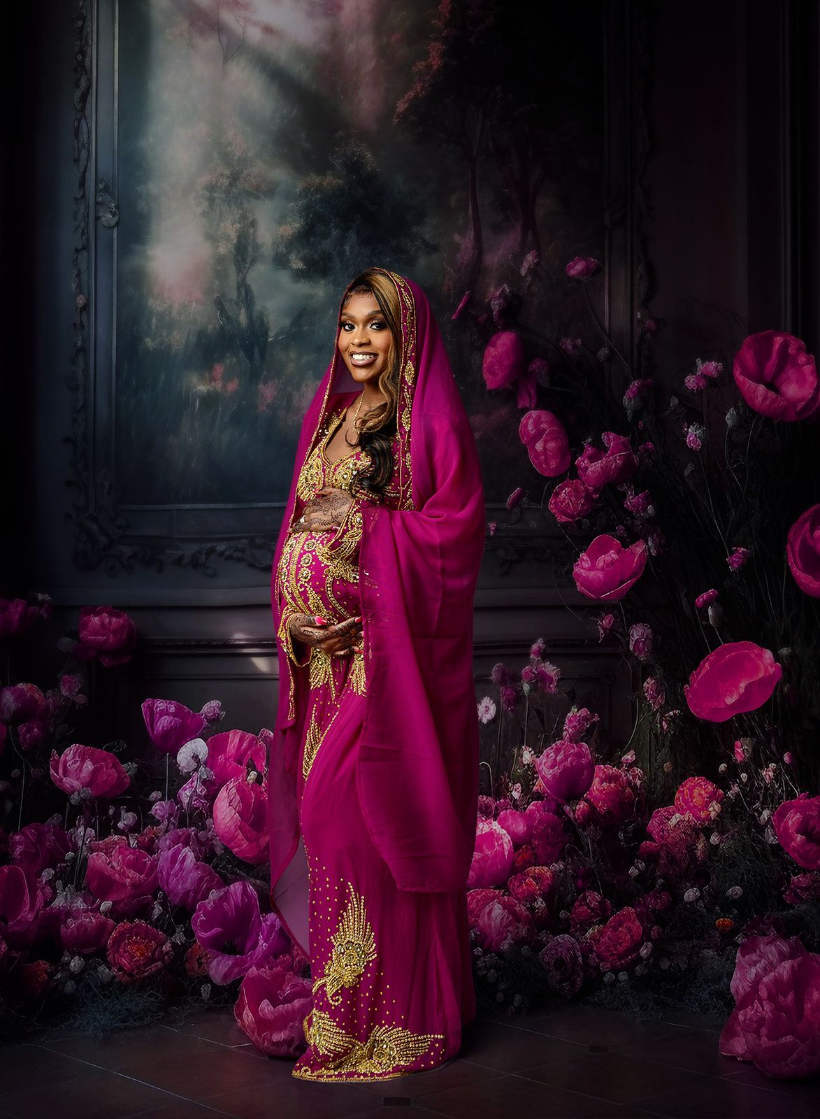 Woman in a magenta and gold sari standing among pink flowers in a dark floral backdrop