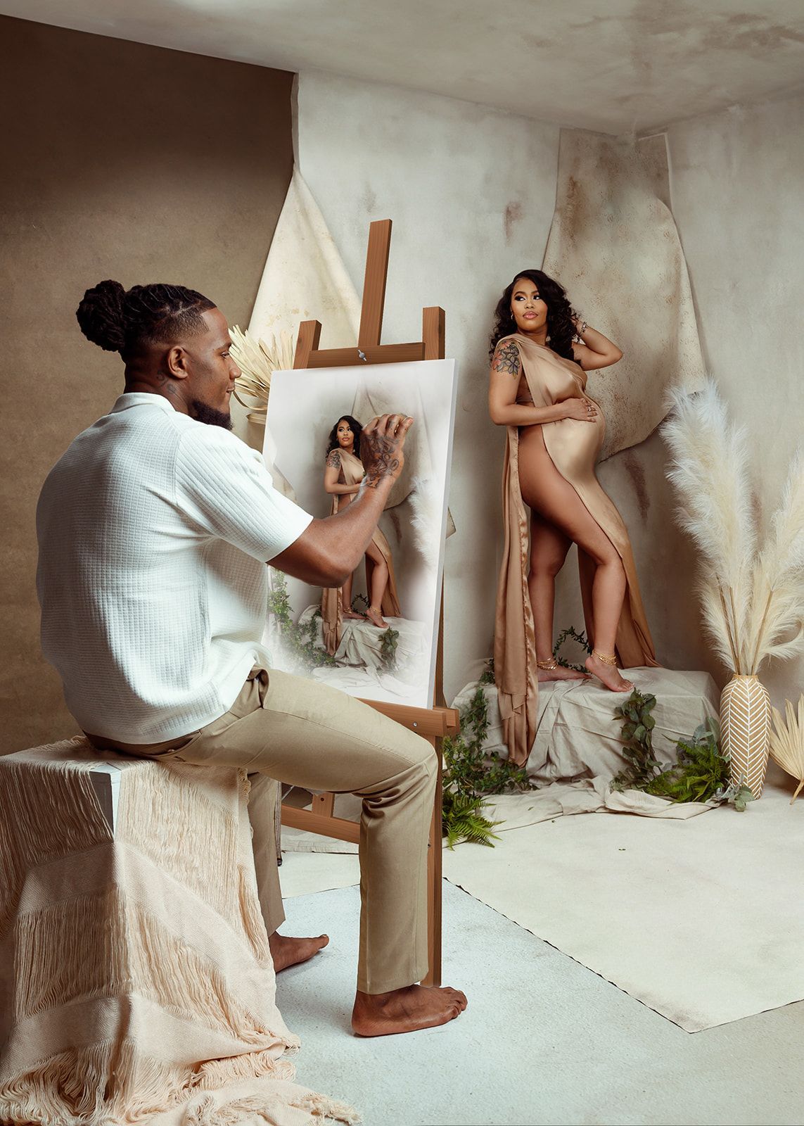 Man painting a nude female model in a minimalist studio with warm beige walls.