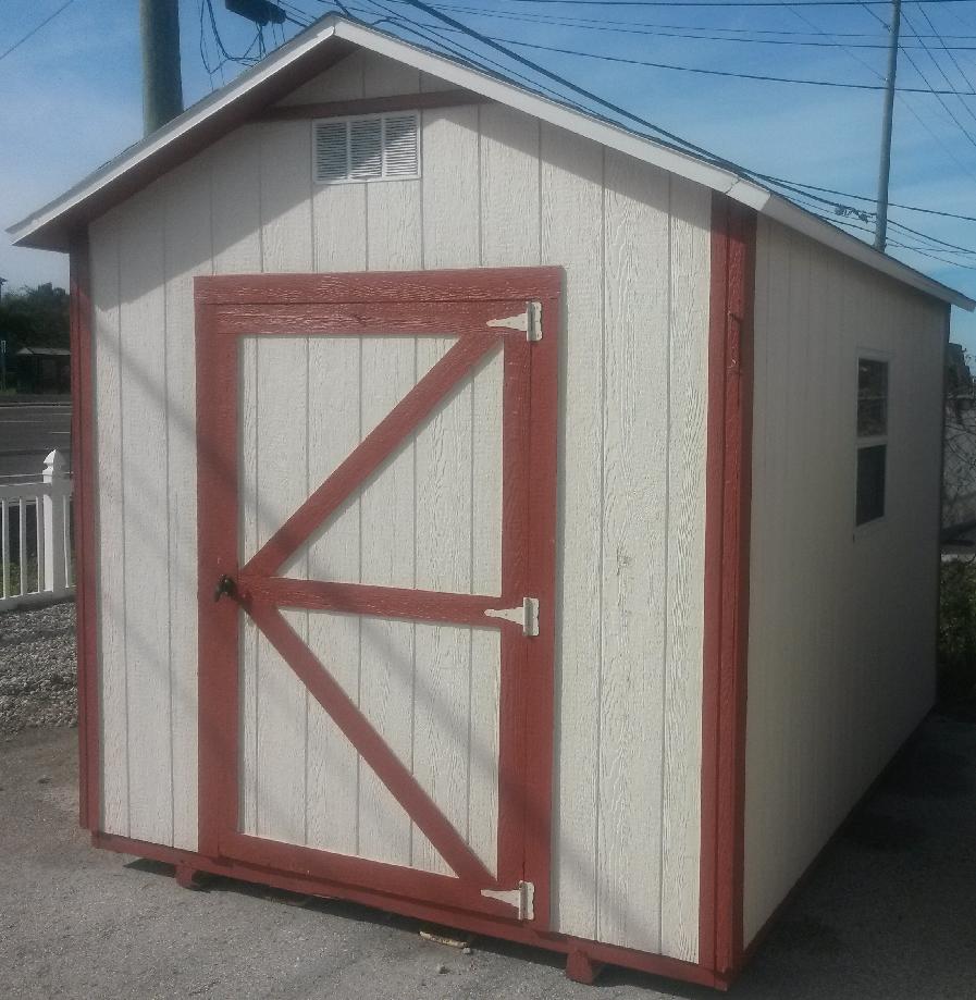 A small white shed with a red door