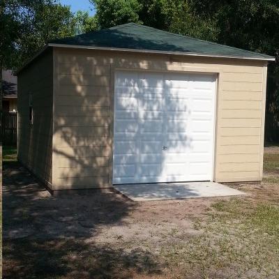 A garage with a white door and a green roof