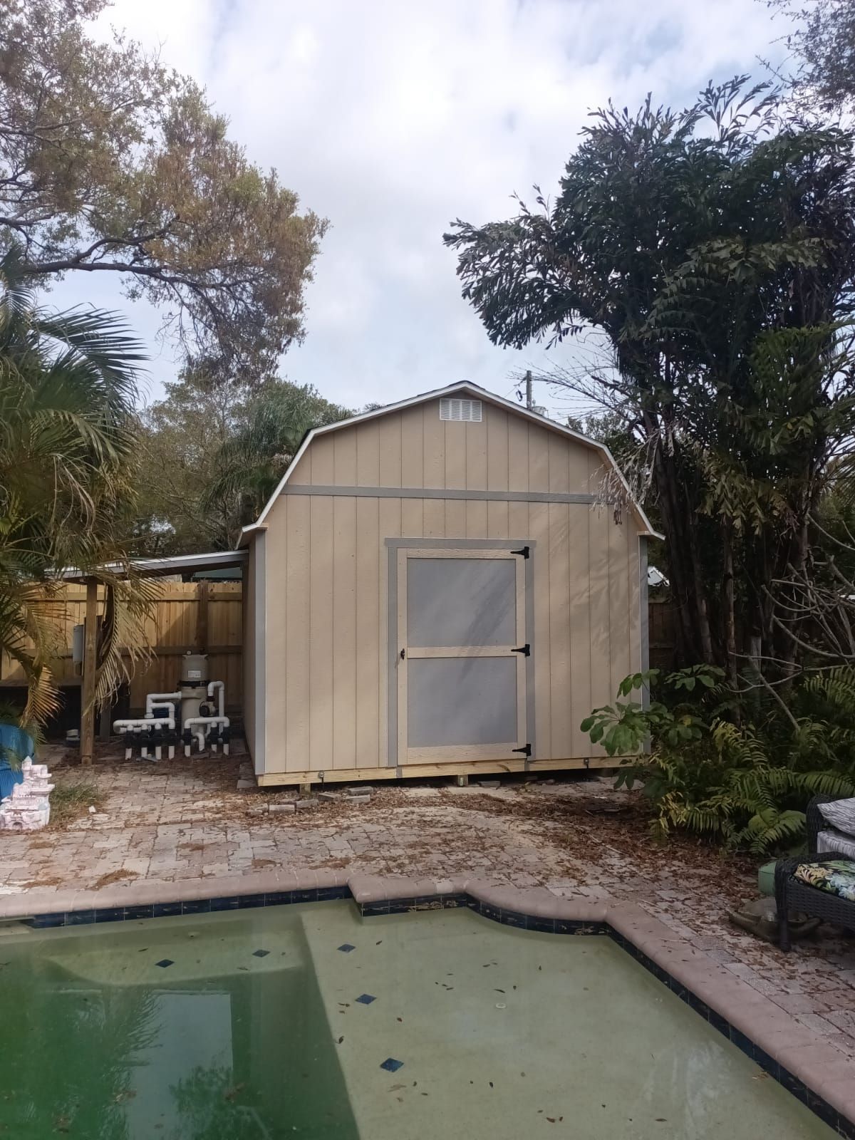 A barn shed sits next to a swimming pool
